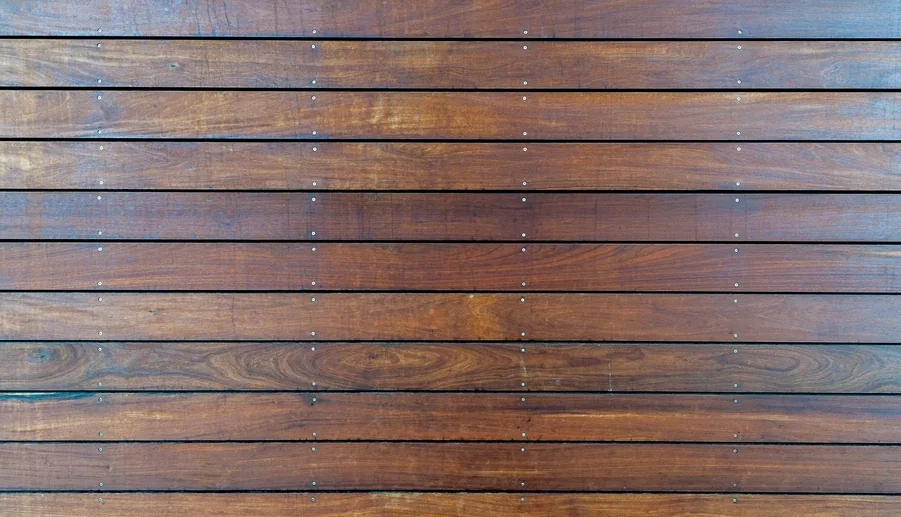 Warm brown deck boards running in a tight line, freshly finished